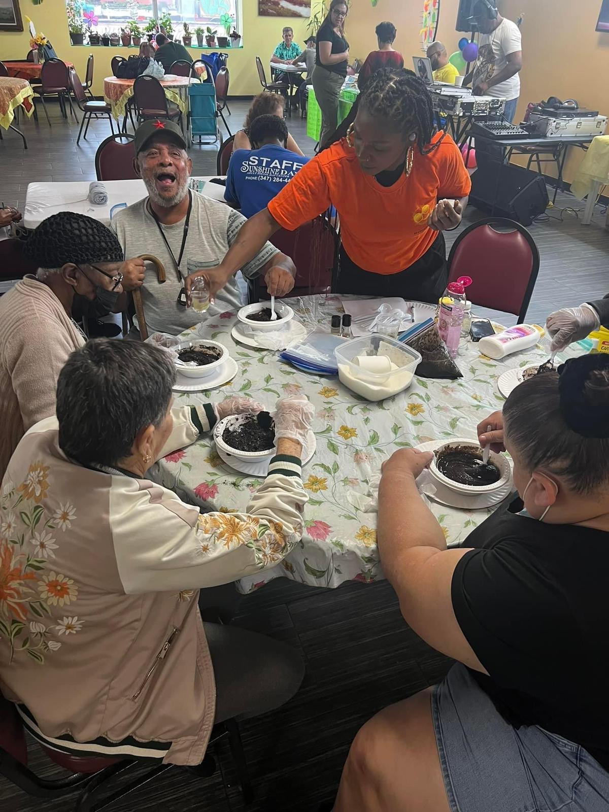 Members enjoying a hands-on group activity with Sunshine Days staff