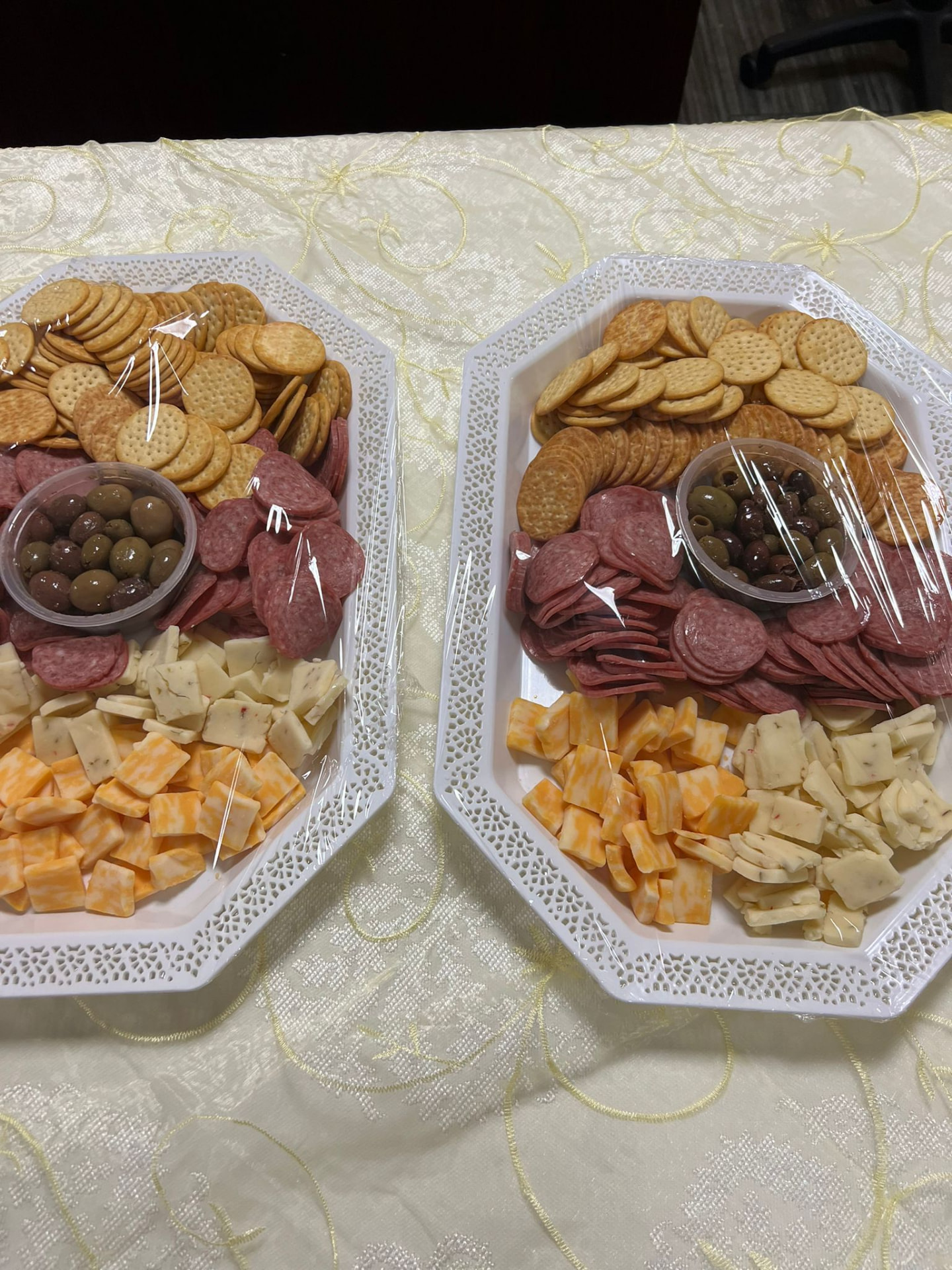 Prepared snack platters with crackers, cheese, olives and sliced meats